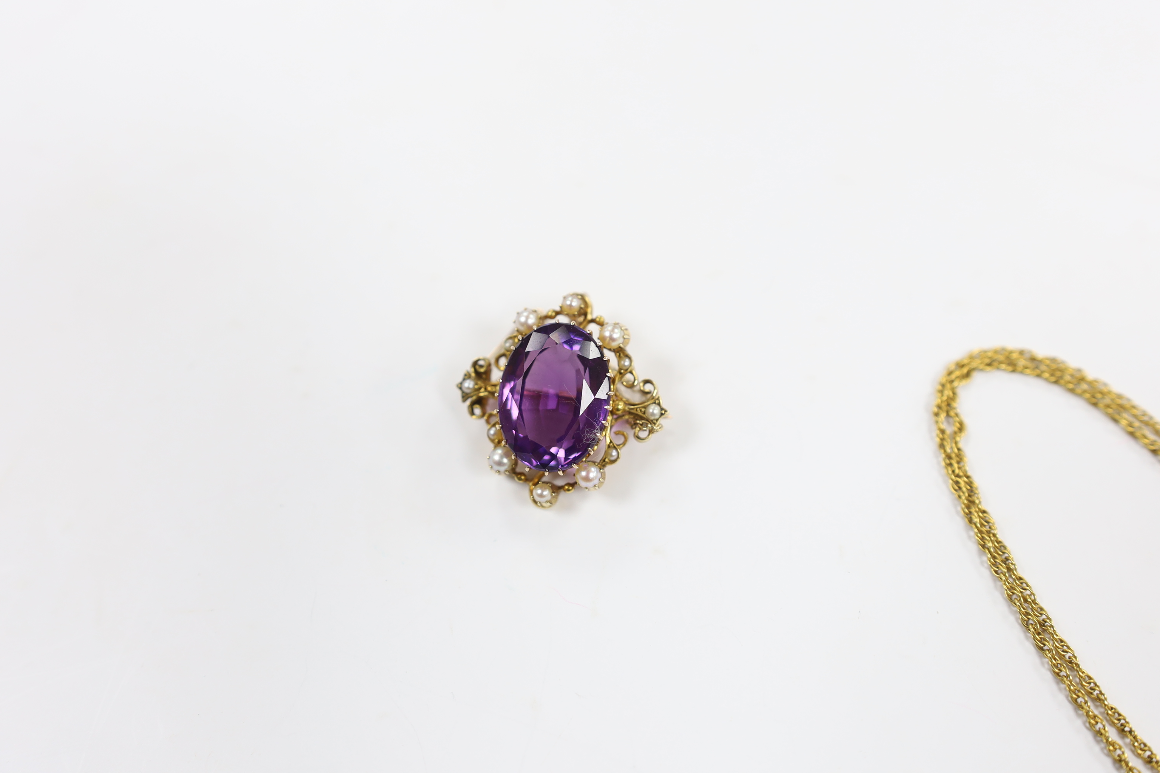 A 1960's 9ct gold, amethyst, seed pearl and diamond chip set drop pendant, 35mm, on a 9ct gold chain, 40cm and a yellow metal, amethyst and seed pearl set oval brooch, gross weight 16.5 grams.